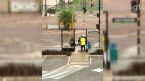 Homem enfrenta enxurrada para recuperar moto arrastada após chuva alagar avenida em Bauru; vídeo