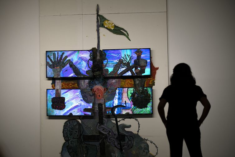 Brasilia 07/02/2023 - Uma mulher é vista em silhueta observando a obra sobre drywall e quatro monitores de TV da serie Teatro Nagô Cartesiano. “A cruz que penetra Pindorama”, do artista, Thiago Martins de Melo, na “Exposicao Brasil futuro - As
